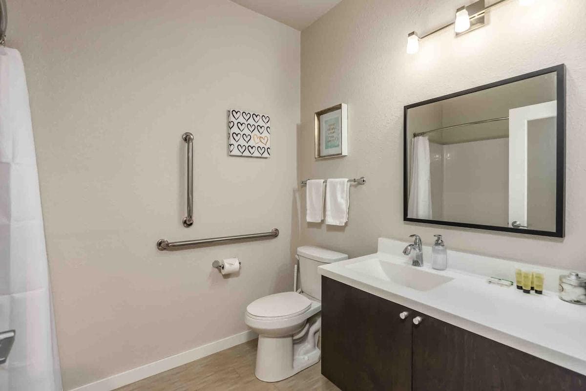 Bathroom with full size tub and shower and support bars.