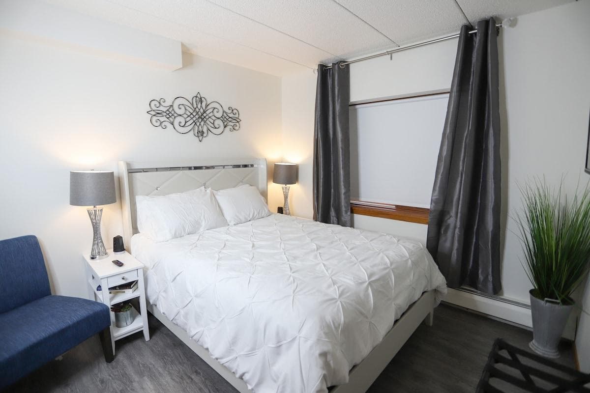 Bedroom with queen mattress, bed side lamps and USB chargers